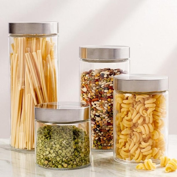 Product photo showing Estilo glass canisters of various sizes filled with pasta, beans, and lentils