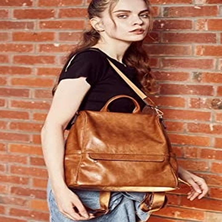 A person wearing the bag as a shoulder bag