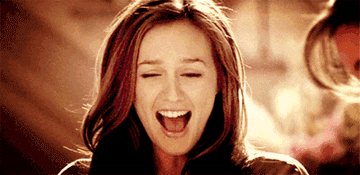 A gif of a young woman smiling excitedly