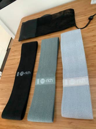 Black, gray, and light blue resistance bands on wooden table