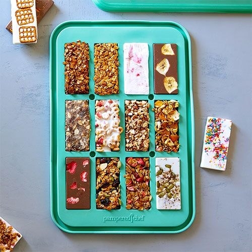 a teal green snack bar mold filled with various homemade treats