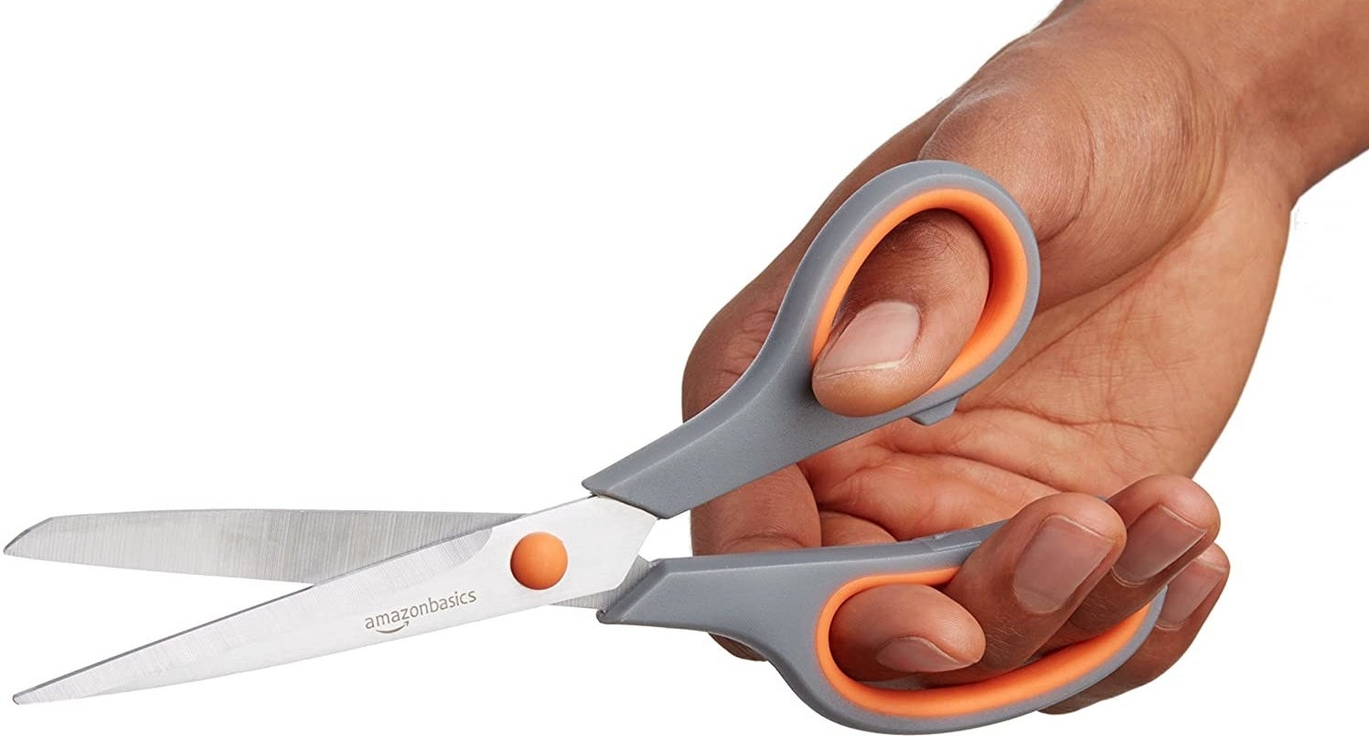A hand holds a pair of scissors