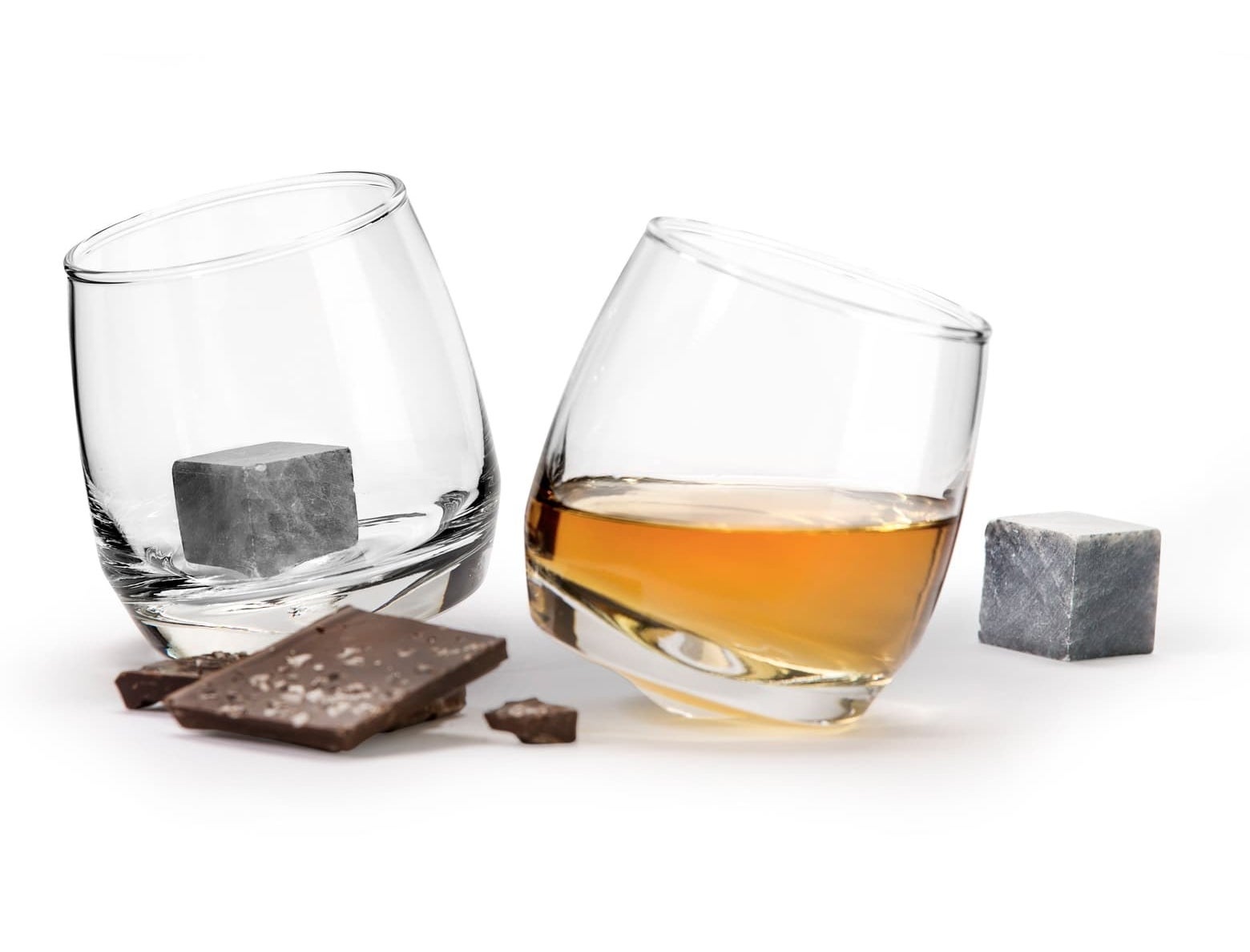 The two glasses one with liquid in it and one with the stone inside and the other stone sitting next to the glasses