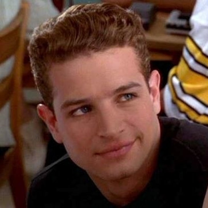 Christian looking up at Cher after he pics up her pen.
