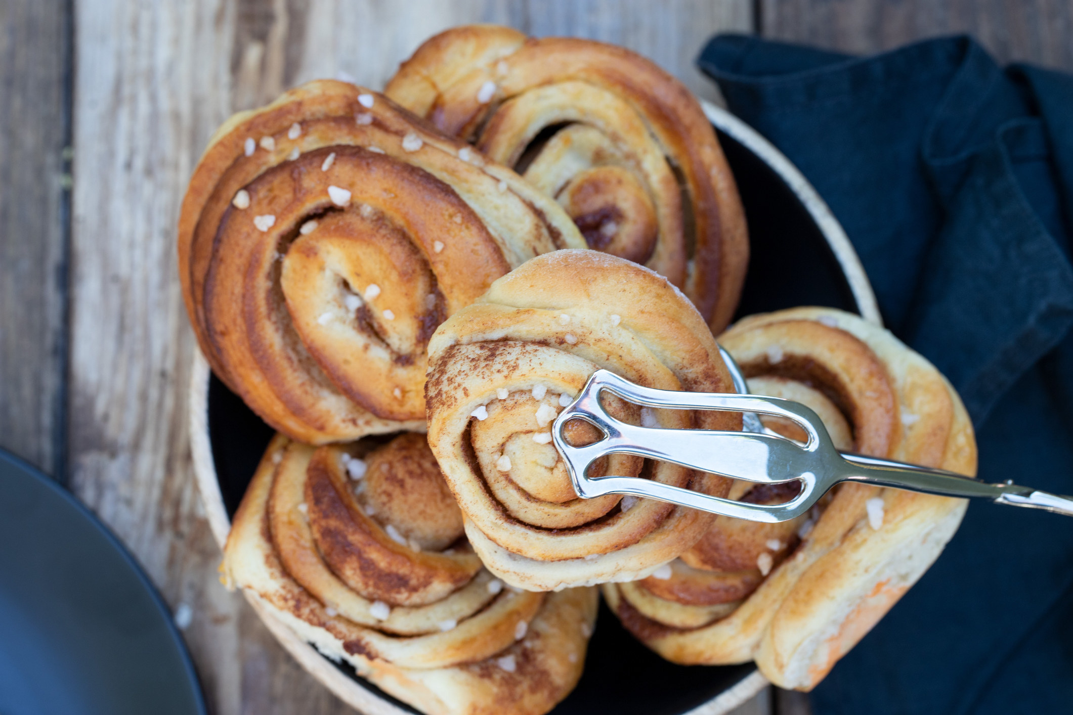 bowl full of buns with swirls of cinnamon running through the dough