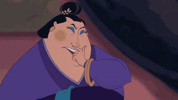 The intimidating matchmaker from Mulan (1998) unknowingly draws an ink mustache on herself as she speaks. 