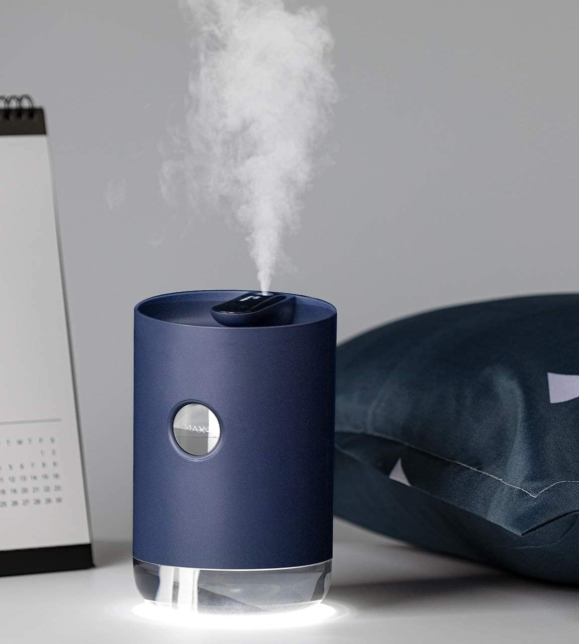 The mini humidifier next to a pillow and calendar