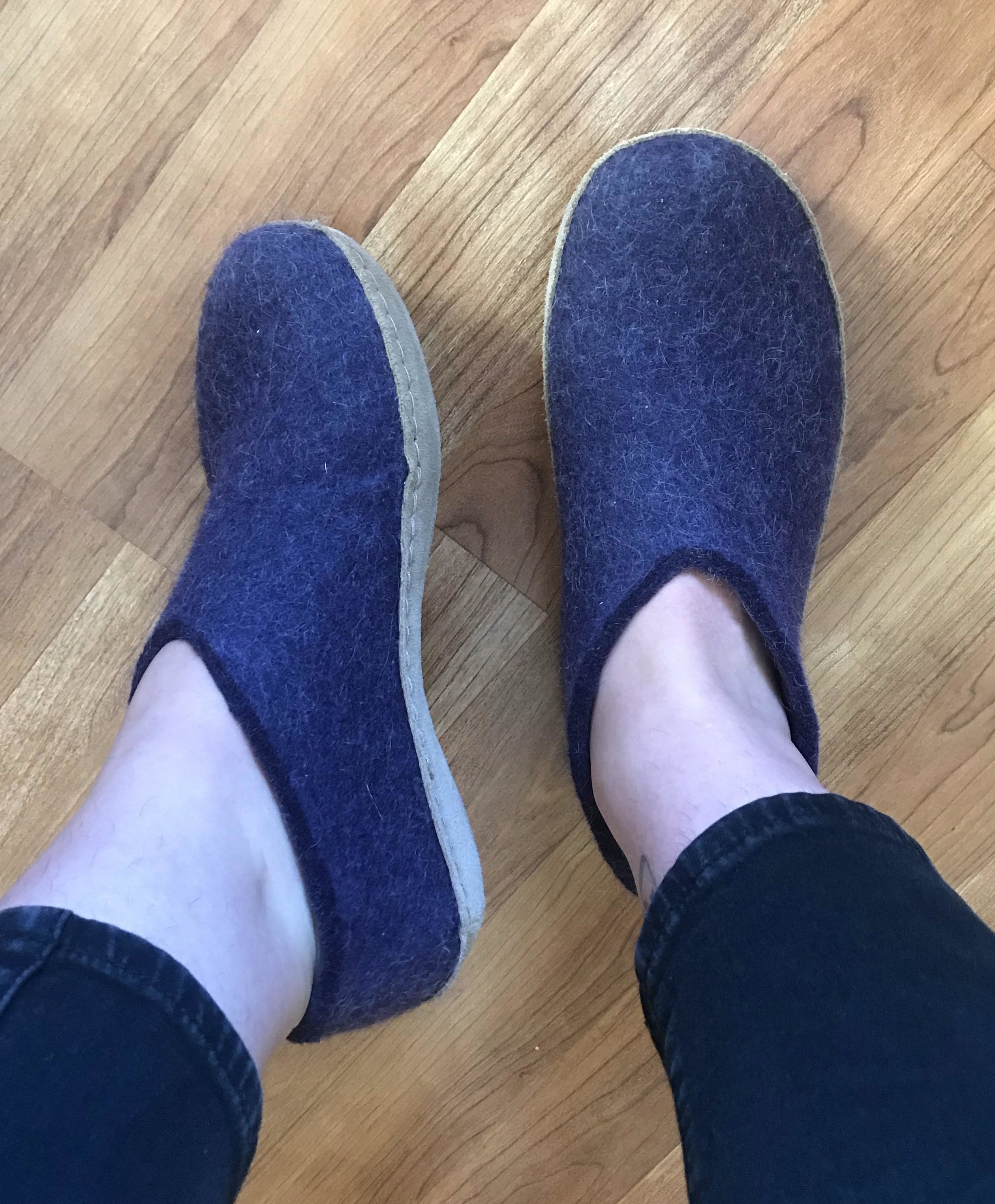 writer in dark purple shoe-like slippers with tan leather soles