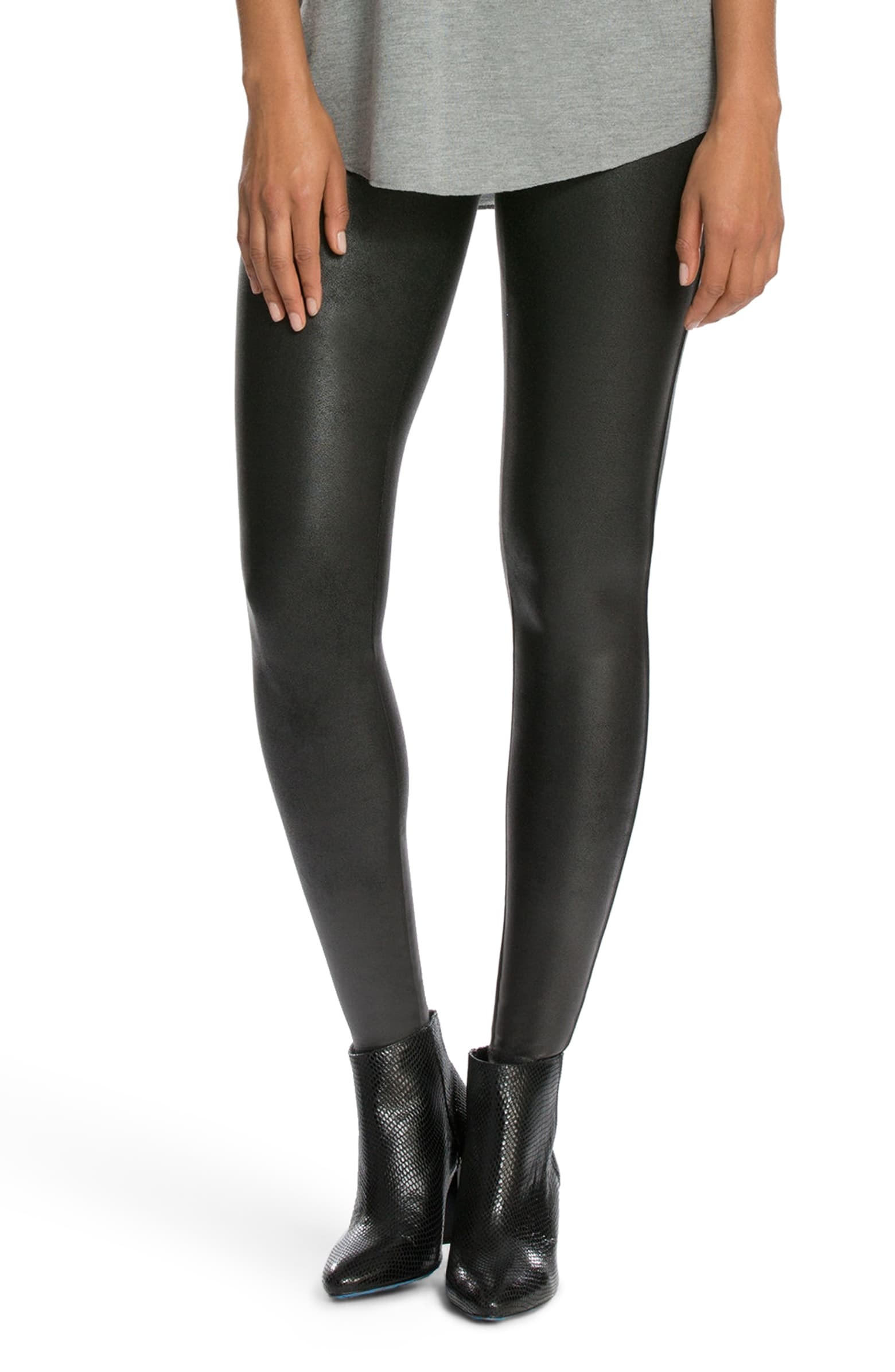 a model in the black faux leather leggings with booties