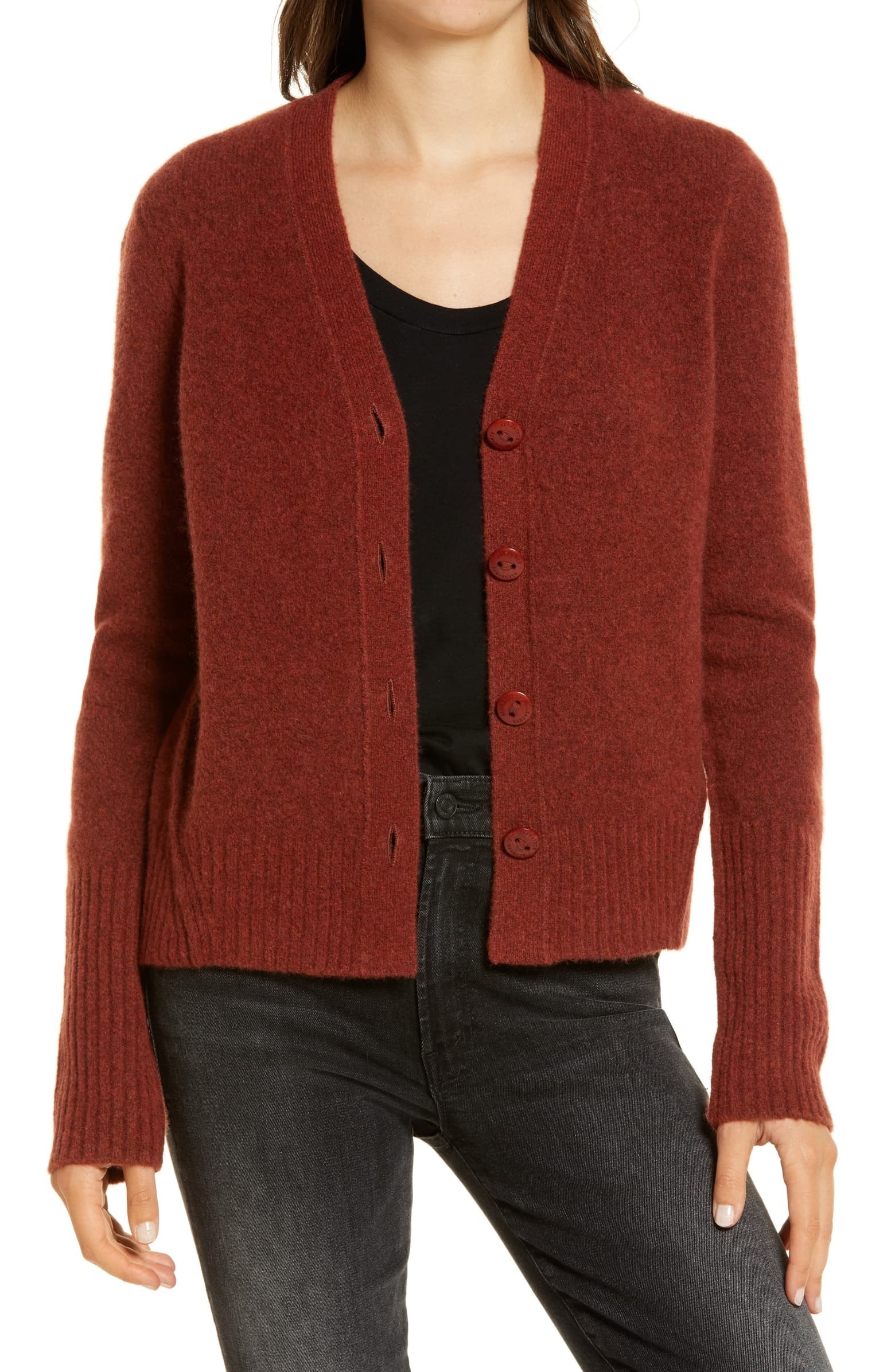 a model in a burnt orange cardigan with buttons down the middle