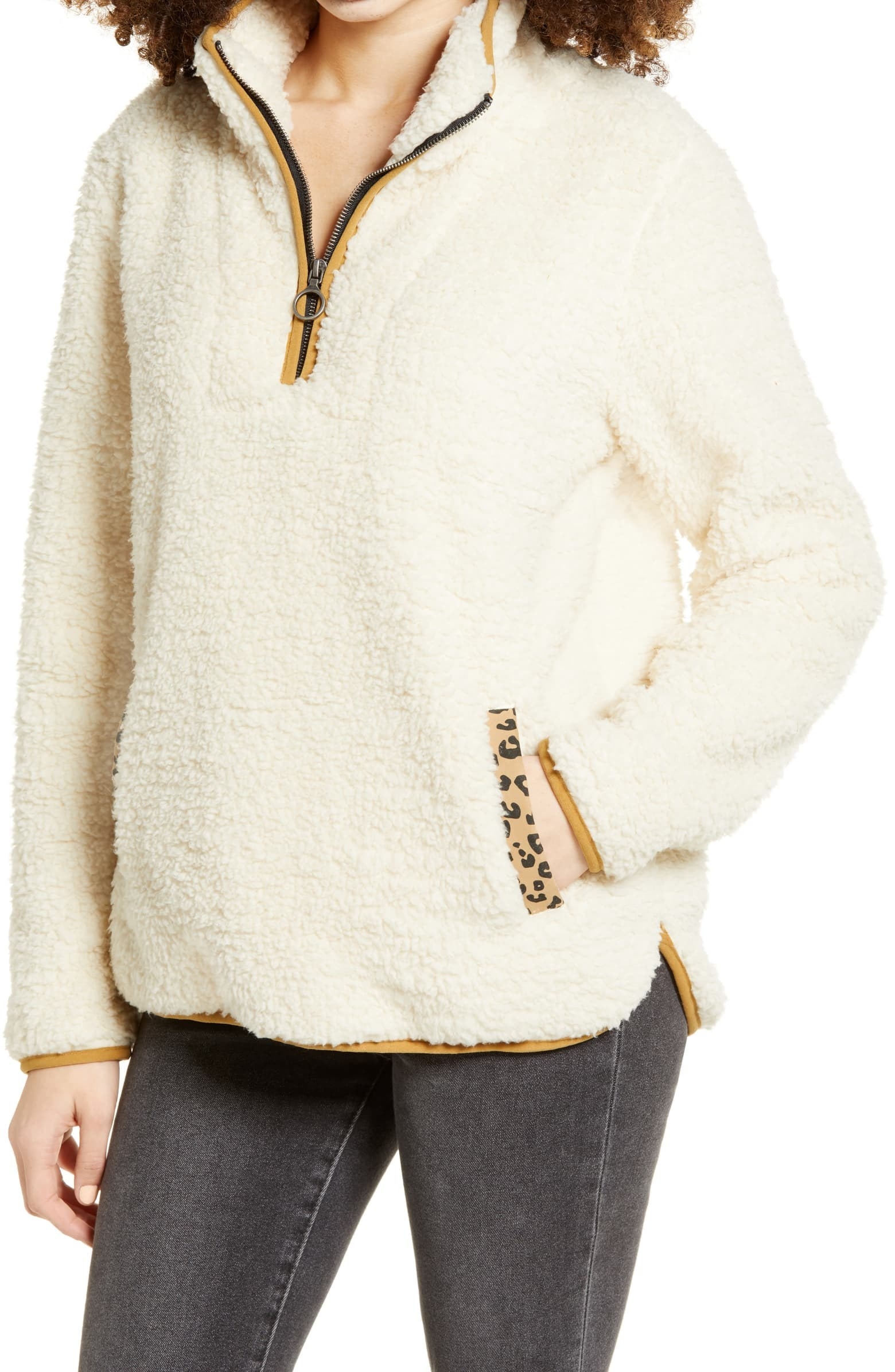 a model in an off-white fuzzy half-zip with cheetah print accents on the pocket