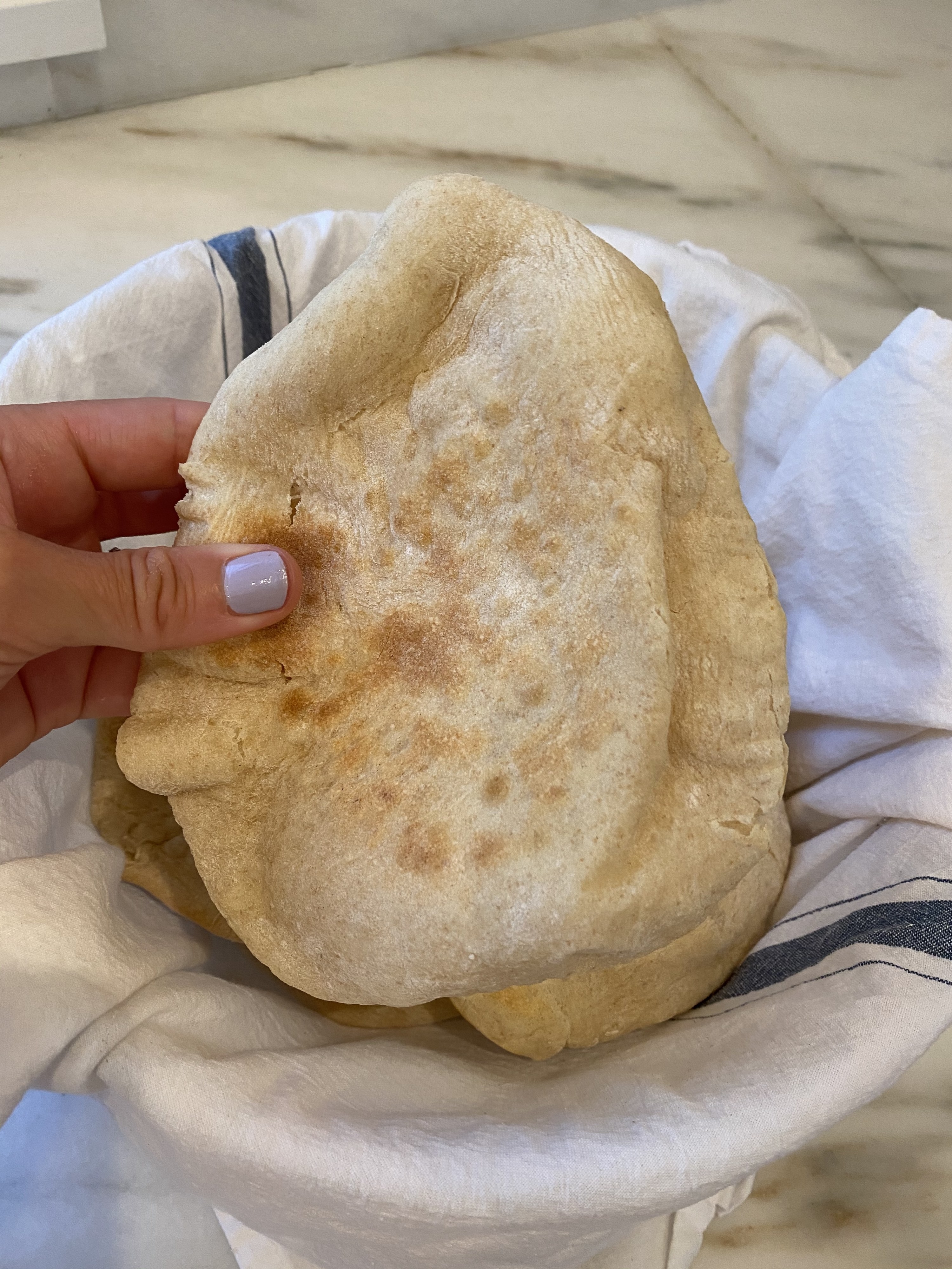 Me, holding a piece of just-baked pita bread.
