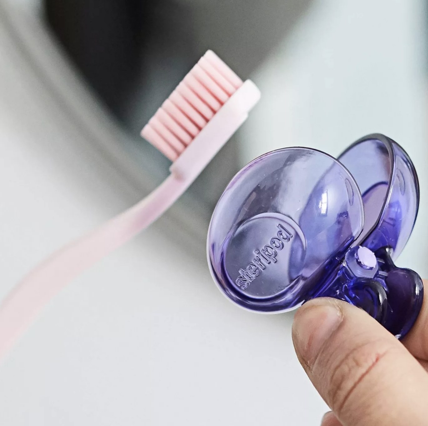 Steripod cover being placed on toothbrush 