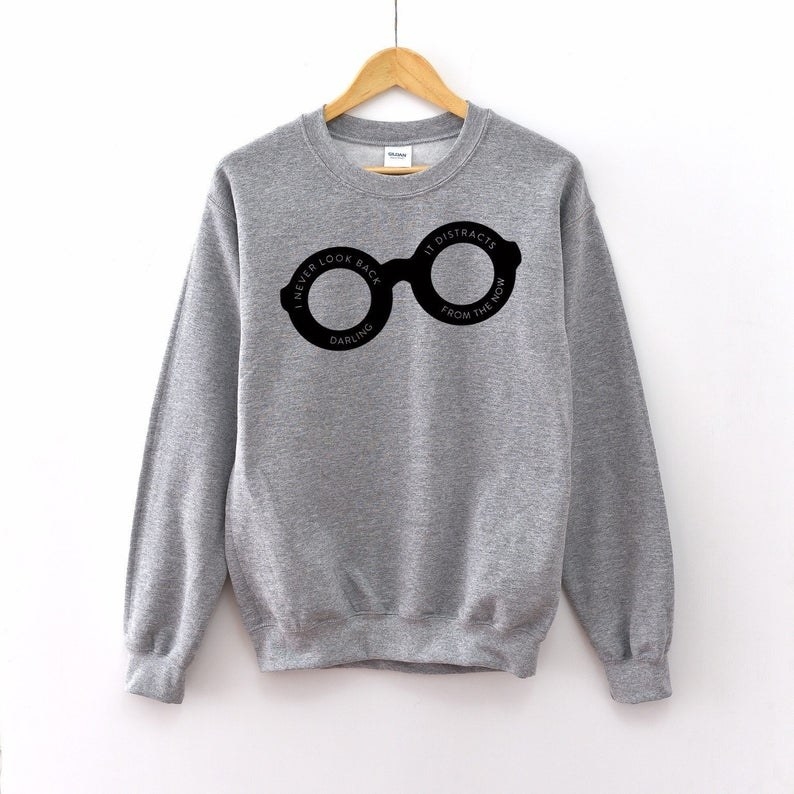 The gray sweatshirt featuring Edna's black glasses printed with a quote