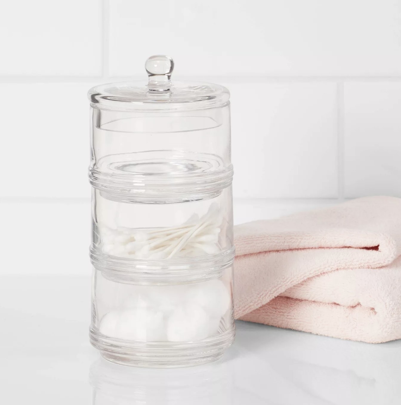 The canister with cotton swabs and cotton balls placed on countertop 