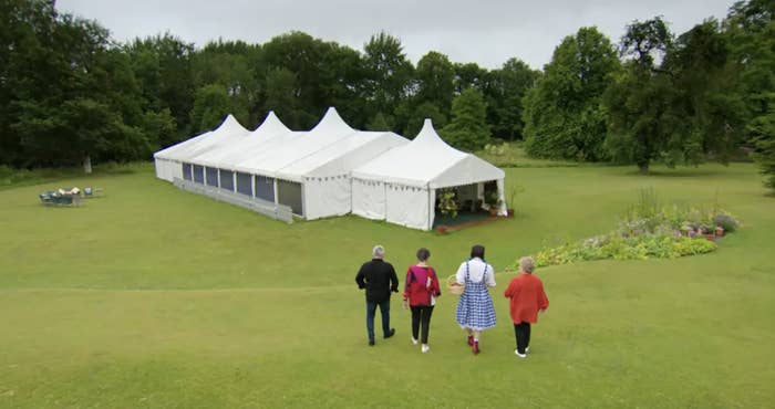 Paul, Prue, Noel, and Sandy walking toward the tent in a previous season