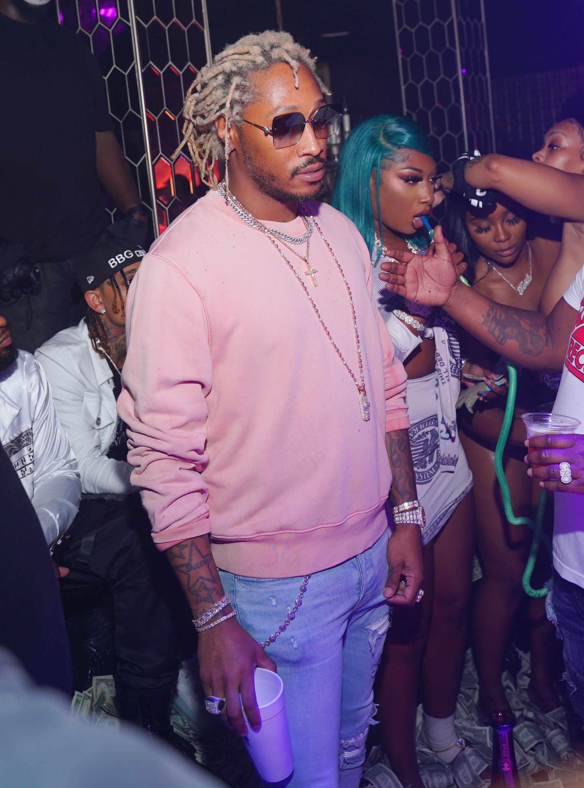 Megan Thee Stallion standing behind rapper Future with bandage on her feet