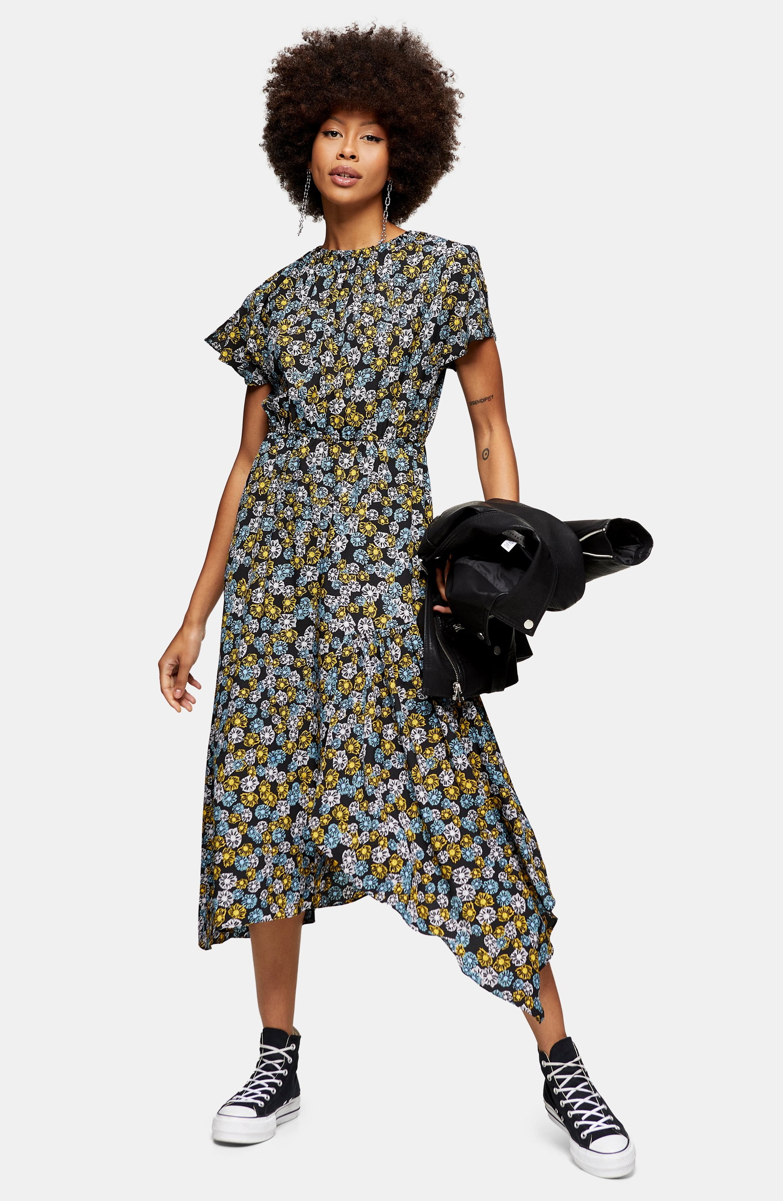 A model wears the Topshop floral print ruched dress with black chucks