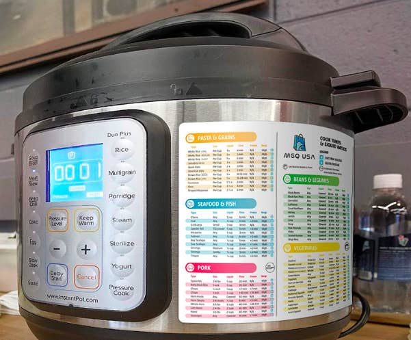 An Instant Pot with the cheat sheet on the side showing pasta, seafood, pork, beans, and vegetable timing 