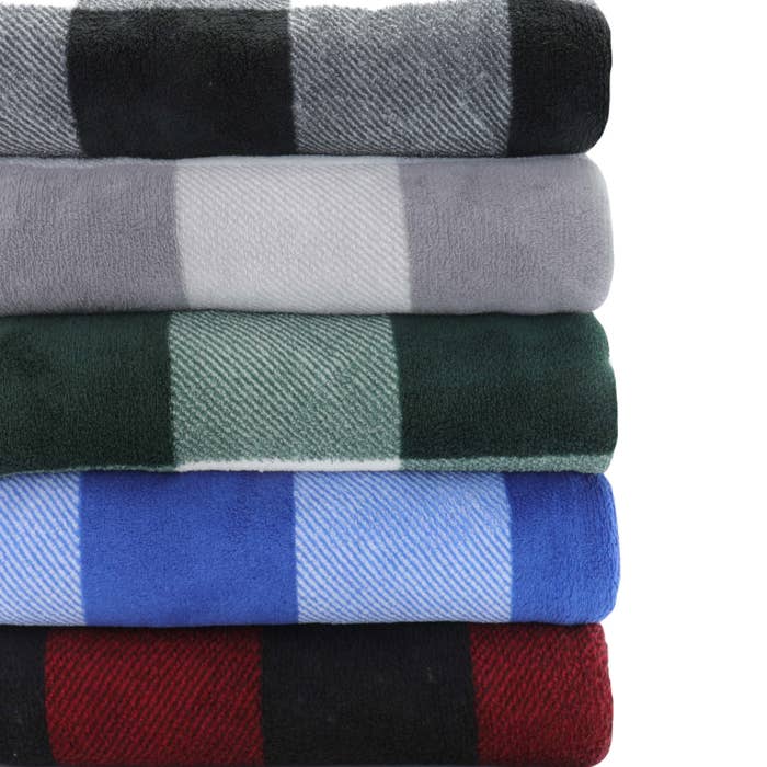 A stack of five folded fleece blankets in different plaid colors