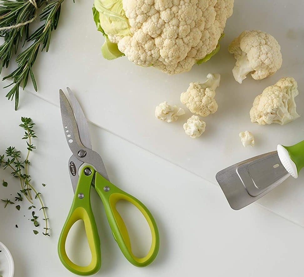 The cauliflower tool next to chopped up florets of cauliflower and a head of cauliflower