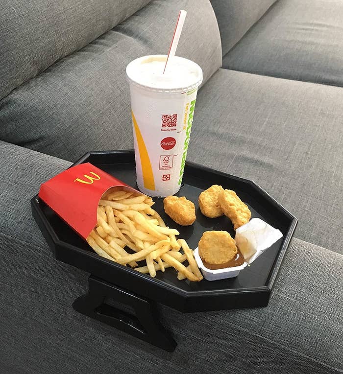 Fries, chicken nuggets, and a drink on top of the arm rest tray