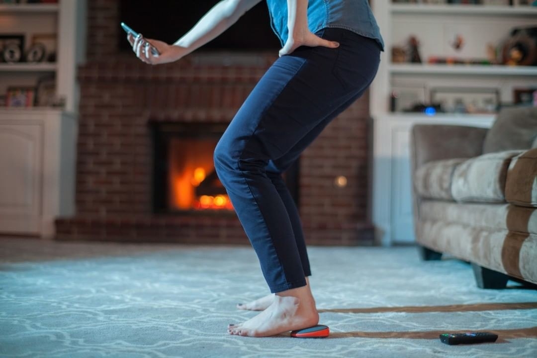 Model uses Activbody Activ5 Training Device under their foot while working out at home