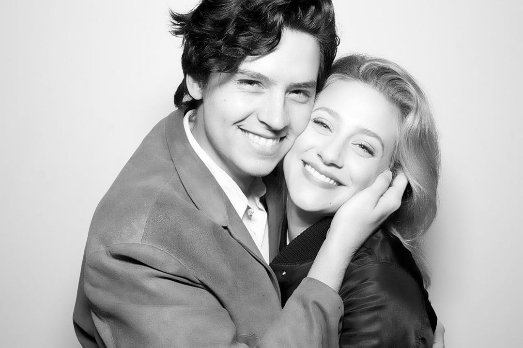 Cole Sprouse holds Lili Reinhart&#x27;s face as they smile for a picture