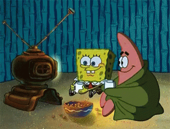 Spongebob and Patrick sit in front of the television with snacks and mugs