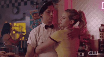 A GIF of Cole Sprouse and Lili Reinhart embracing in a scene from "Riverdale"