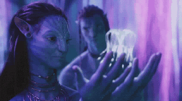 Neytiri gently blowing a jelly fish-like creature away in &quot;Avatar.&quot;