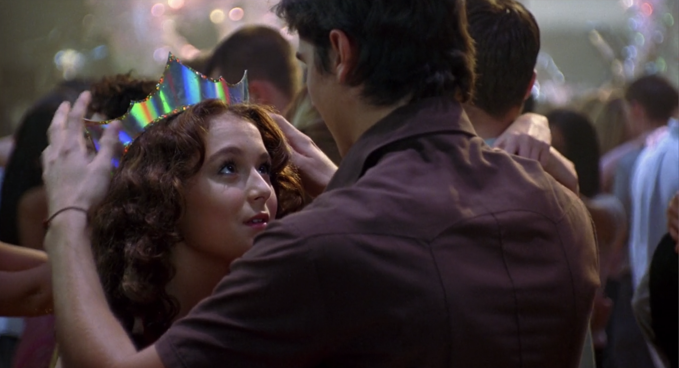 Steve places the iridescent crown on Julie&#x27;s head at the school dance. 