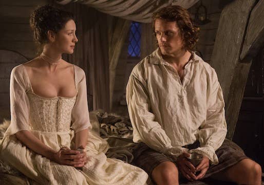Claire and Jamie sitting on their marriage bed. 