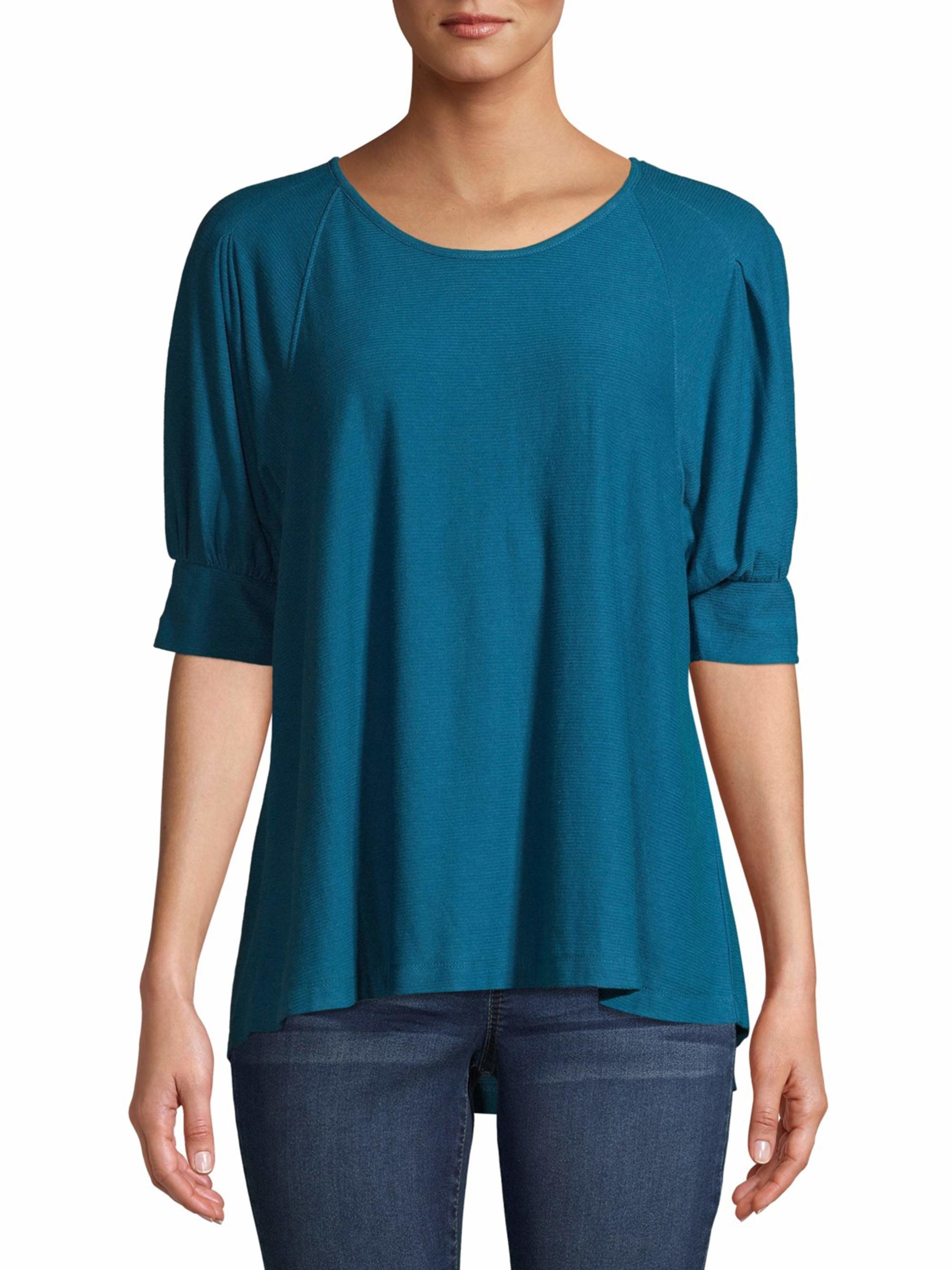 Model in a blue elbow-length sleeved pleated top 