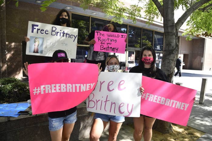 Five protesters holding signs that say &quot;#FreeBritney&quot; and &quot;The world is rooting for you Britney&quot;