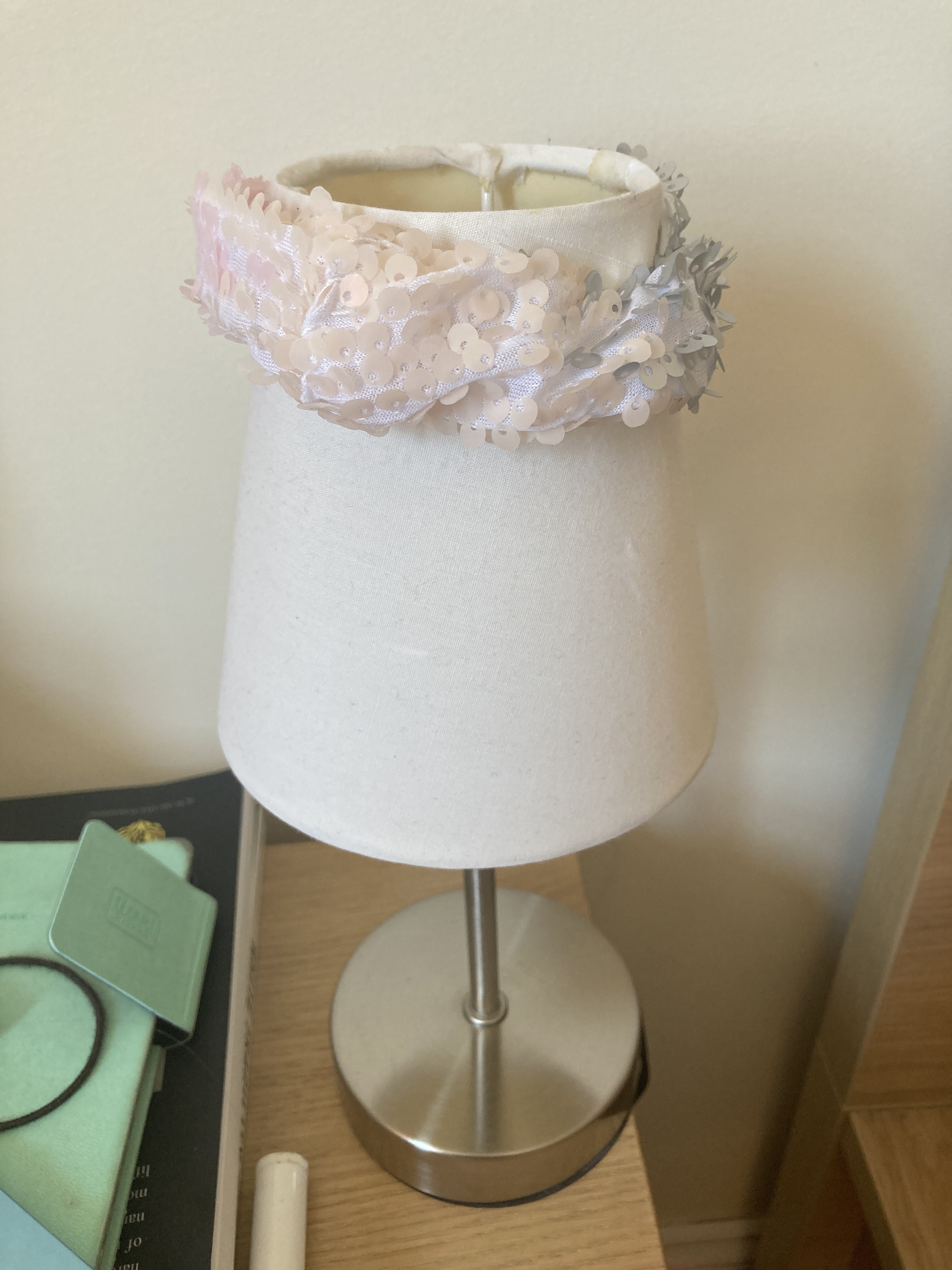 A small desk lamp with a sparkly scrunchie on top