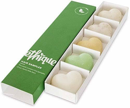 a long green box next to a long rectangle insert with five spaces filled with heart-shaped shampoo and conditioner bars
