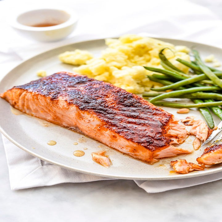 A plate containing a piece of maple glazed salmon, green beans, and potatoes.