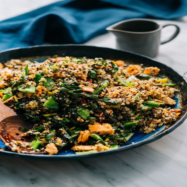 A quinoa and salmon salad with chard all mixed together in a bowl.