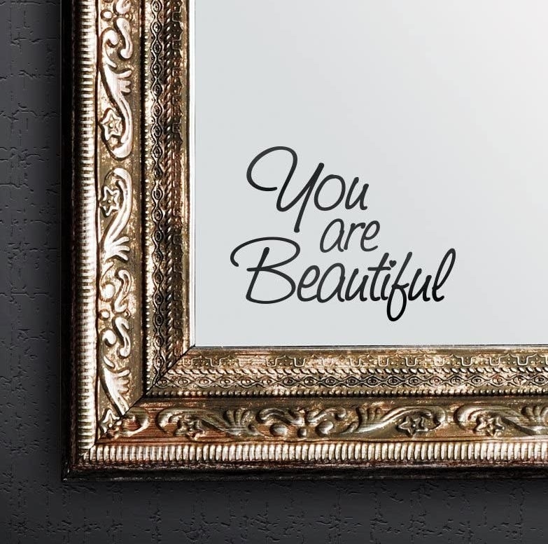 The "you are beautiful" sticker on a mirror