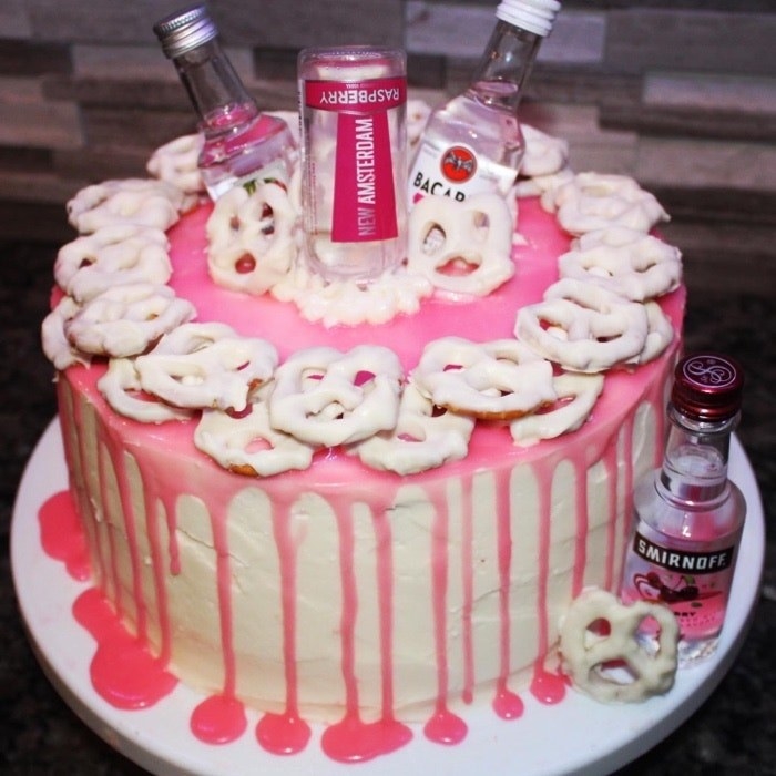 Birthday cake decorated with frosted pretzels and little bottles of alcohol