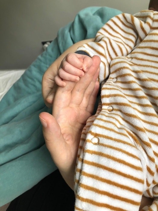 A baby hand holding its mom&#x27;s hand