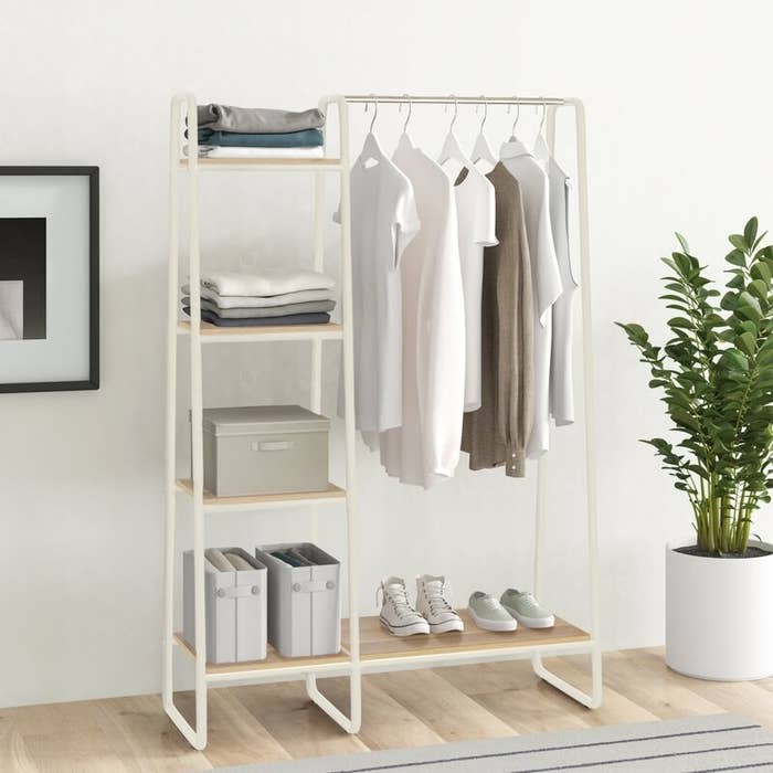 A white multi-shelf garment rack with a clothes bar