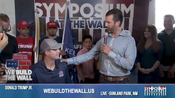 Donald Trump Jr. stands next to Brian Kolfage with his hand on Kolfage's shoulder.