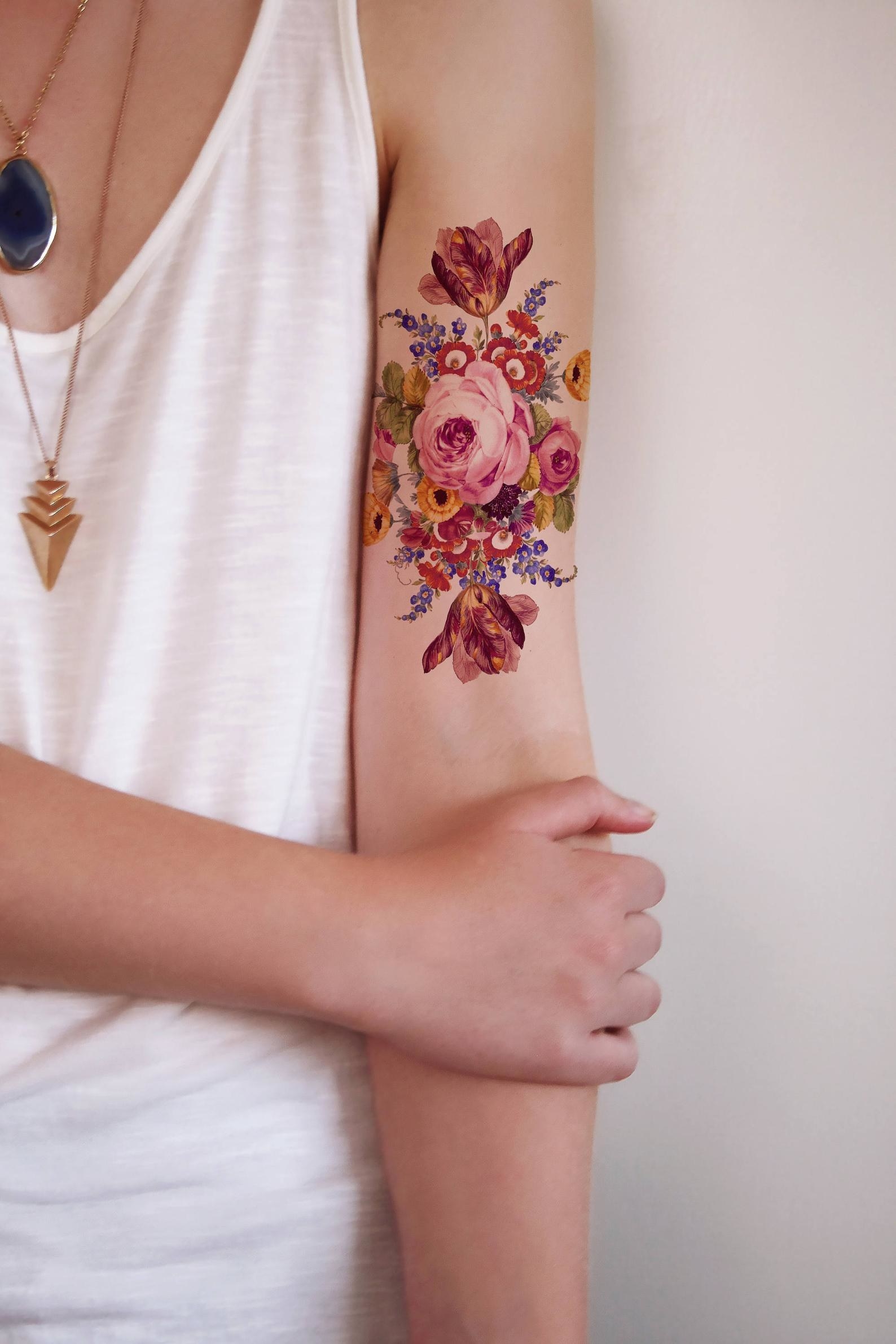 Big floral tattoo on the inside of a model&#x27;s upper arm