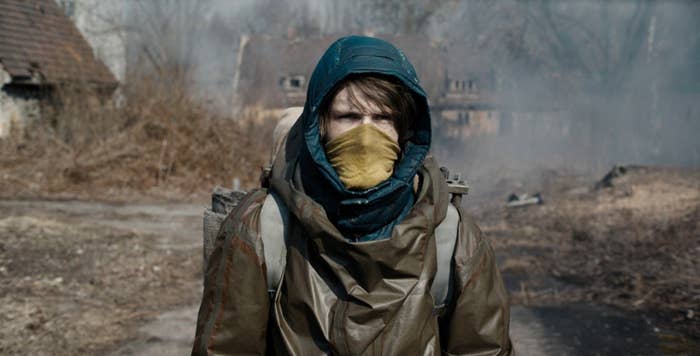 Dark still: Jonas wears a mask and walks through a post-apocalyptic town