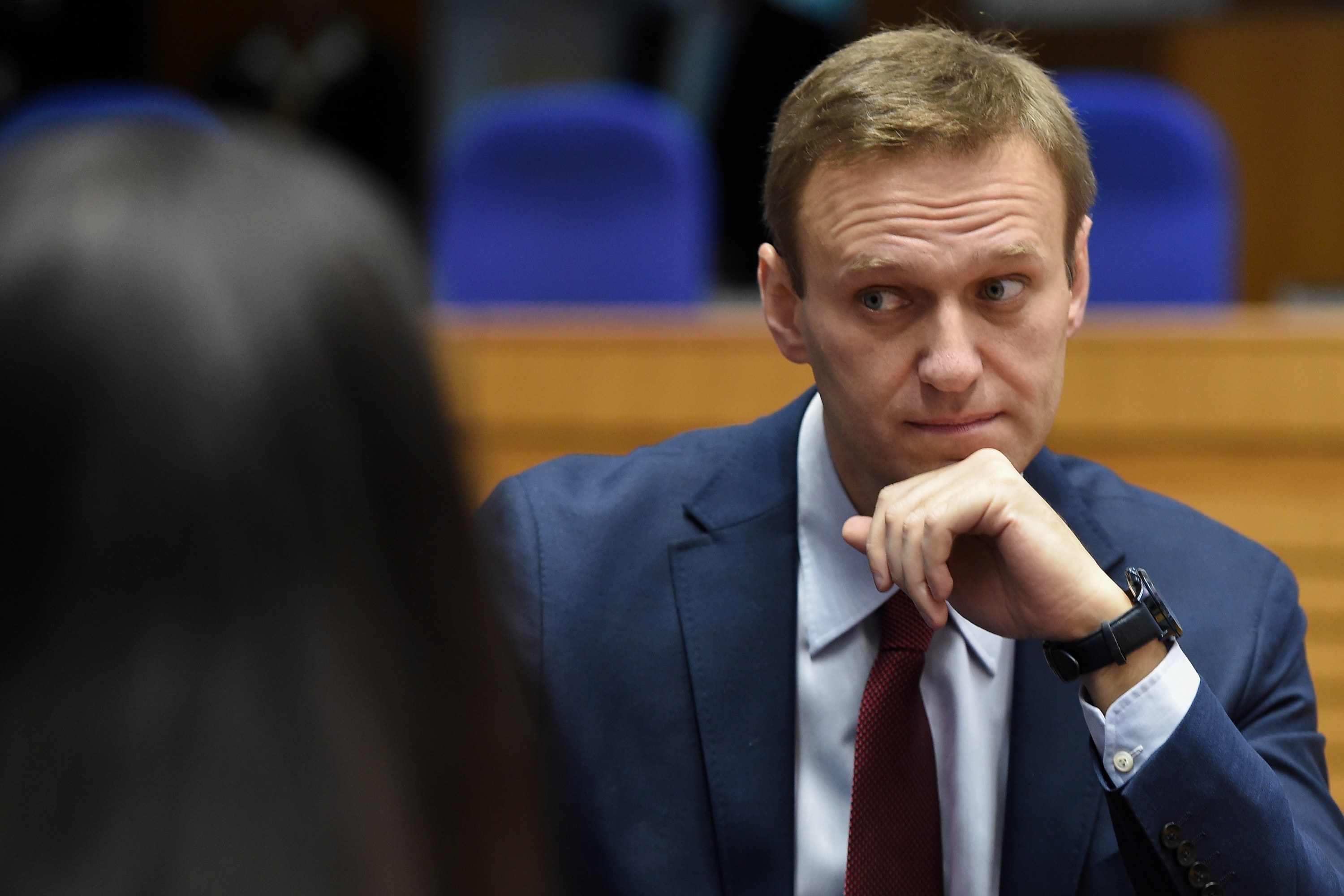 Navalny sits wearing a suit at a hearing