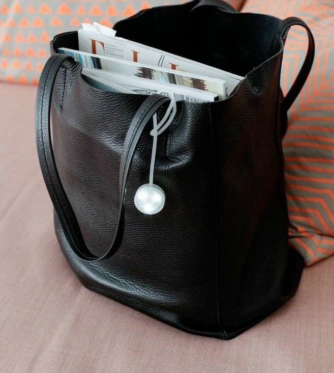 A purse light attached to the handle of a tote bag
