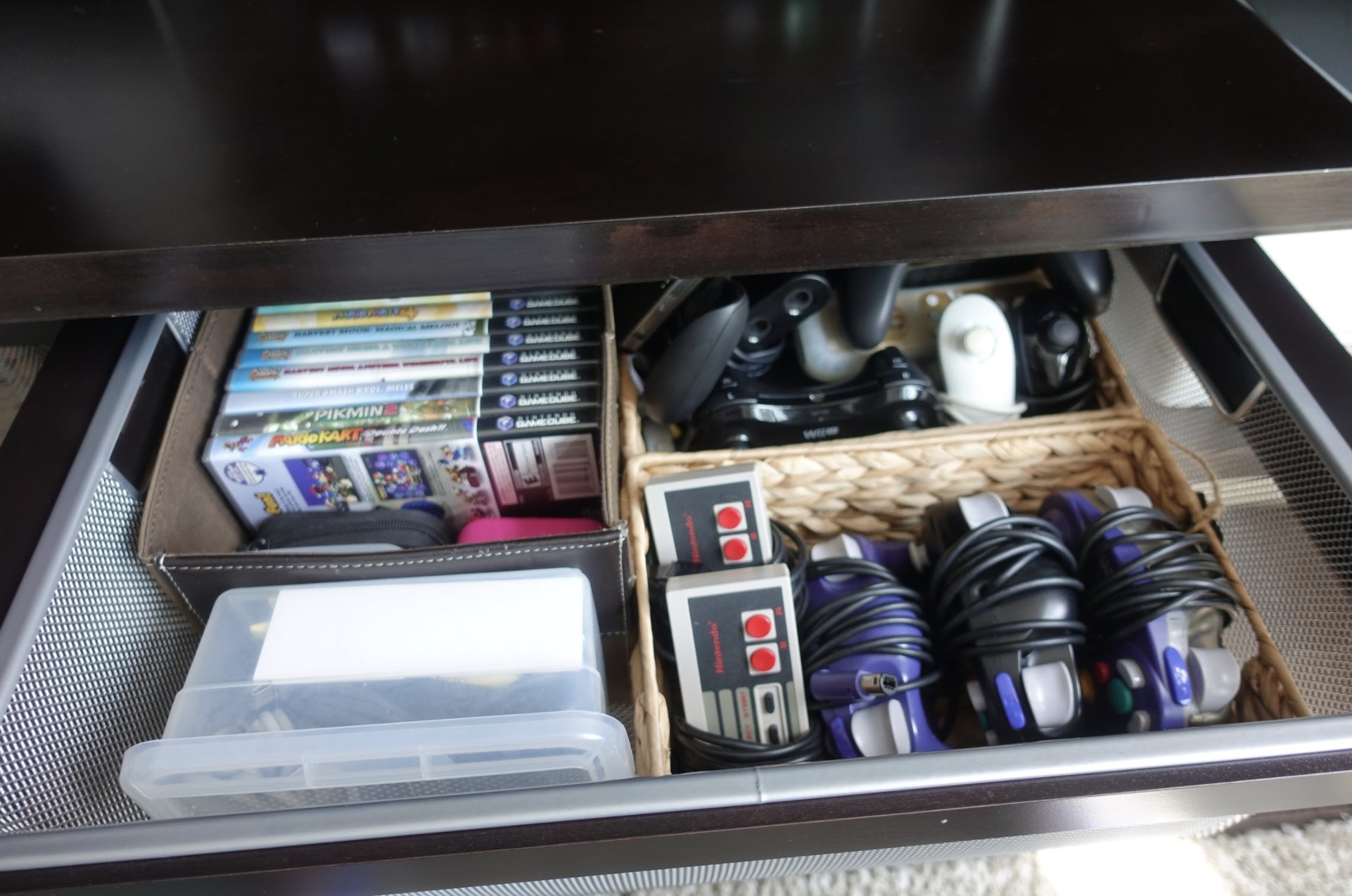 A drawer of video games and video game controllers