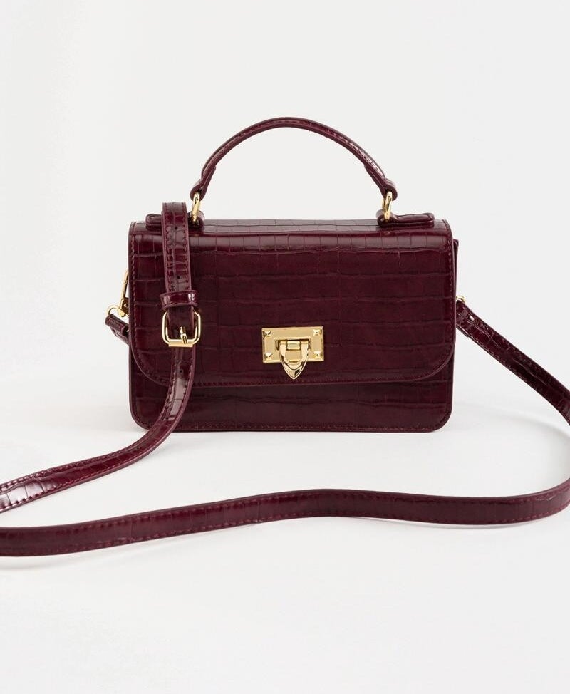 a faux crocodile bag with a long strap and a handle strap